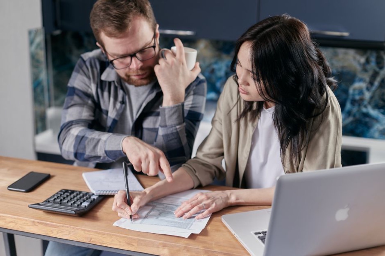 Looking at finances on laptop - Benefits of debt counselling
