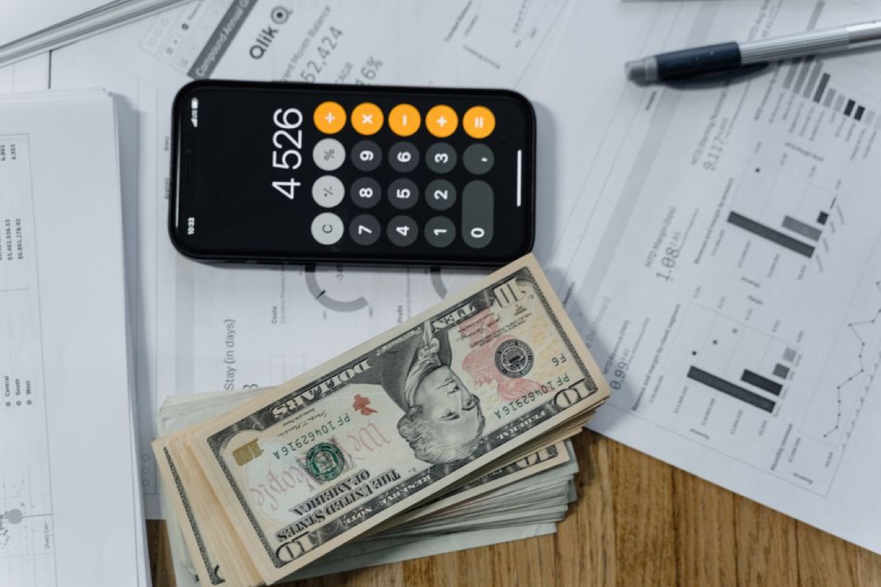 Stack of bills and a calculator - How much does it cost to remove debt review?