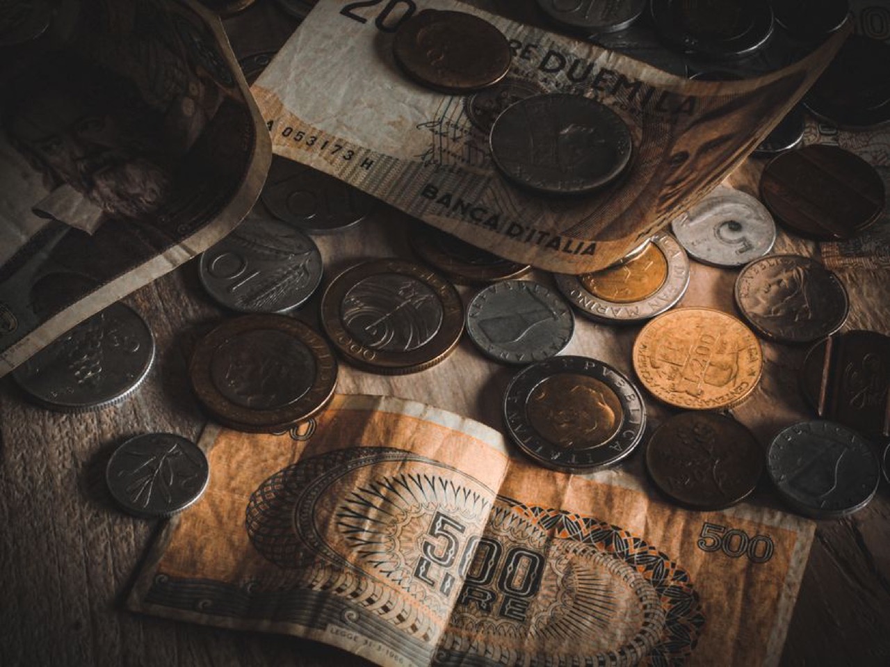 Bills and coins on a table - Debt review meaning: what 'under debt review' means