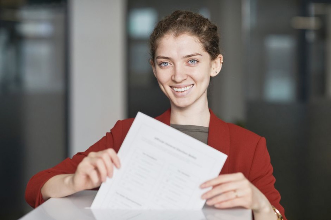 Smiling person with paperwork - Debt review removal companies: be careful