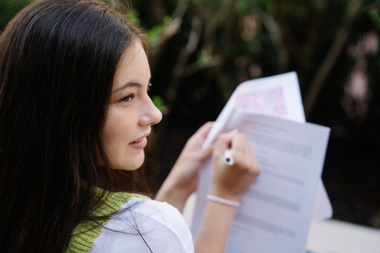 Smiling person with paperwork - How to choose a debt counsellor