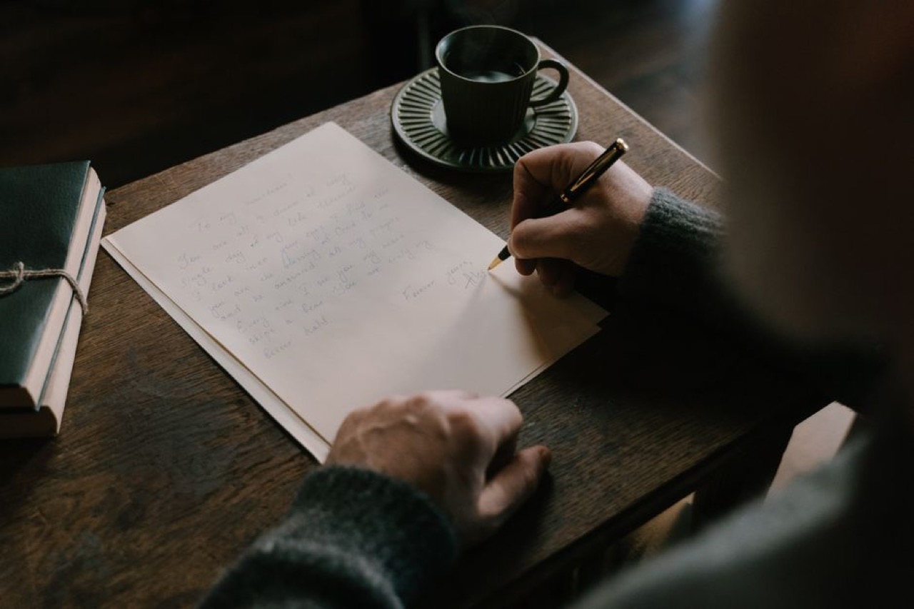 Writing a letter at desk - Financial hardship letter (template)